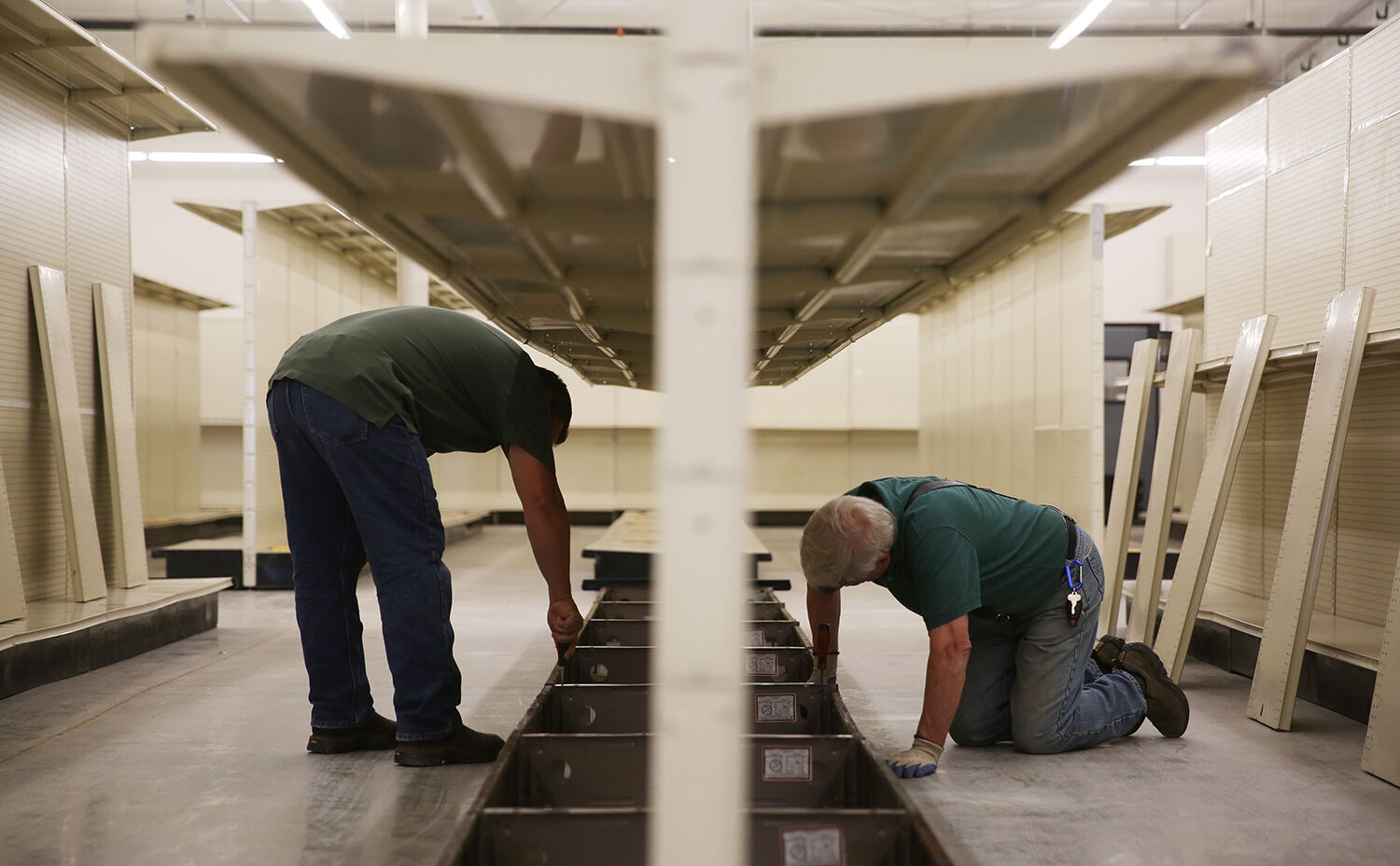John Zorbas, left, and Steve DuMond work together to level